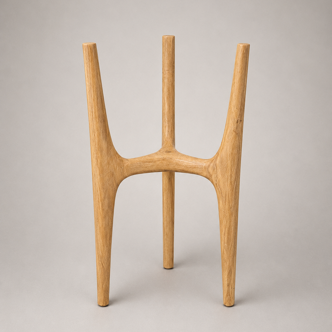 A minimalist wooden plant stand with three tapered legs and a curved central base, crafted from light natural wood, shown on a neutral gray background.