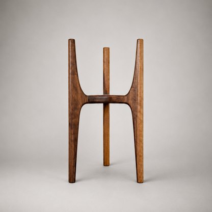 A mid-century modern wooden stand or small table with three tapered legs and a curved seat, made from dark brown wood, photographed against a neutral gray studio background.
